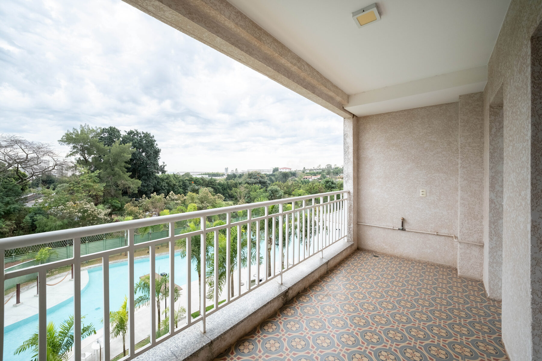Varanda do apartamento com vista aberta para a piscina